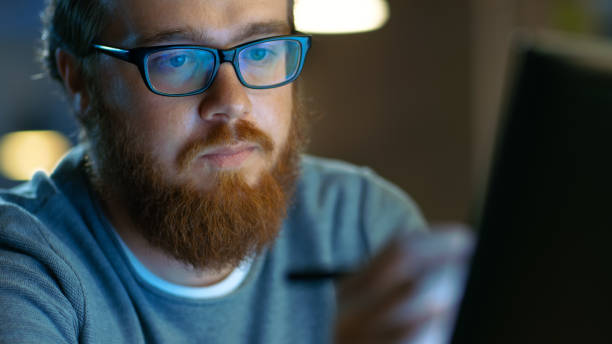 istock Talented Young Concept Artist Drawing on a Digital Pen Display Tablet While Sitting at His Working Place in Modern Loft Office. Late at Night. 846844614