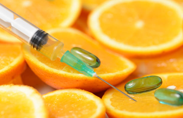 istock Orange in a Cut and a Syringe With Vitamin C 846847450