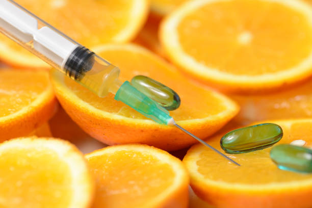 istock Orange in a Cut and a Syringe With Vitamin C 846856142