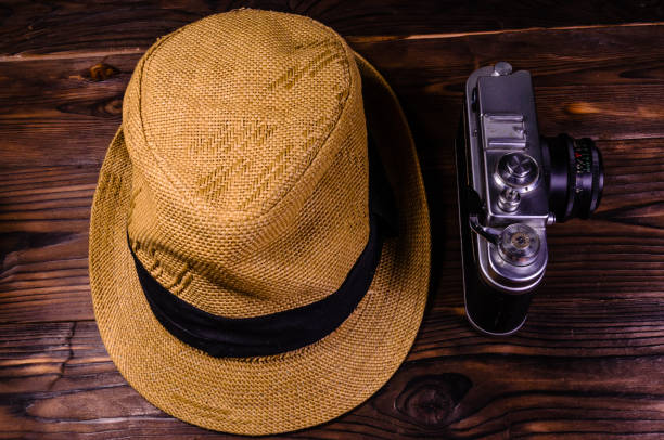 istock Old rangefinder camera and hat on a wooden table. Top view 846859268