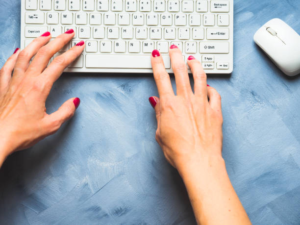 istock Blue background with woman's hand and keyboard 846860912