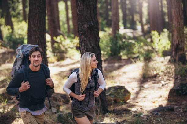 istock Hiking couple walking in forest wearing backpacks 846863314