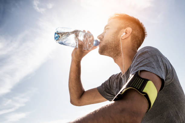 atleta, descansando e refrescante com água - drinking men water bottle - fotografias e filmes do acervo