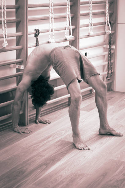 professeur de yoga fait backbend pont souplesse et résistance asana position formation ingym - yoga men bridge bending over backwards photos et images de collection