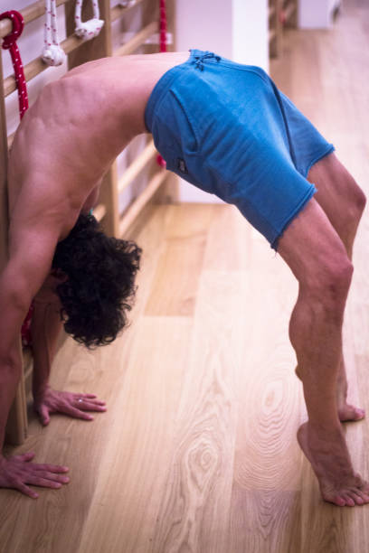 professeur de yoga fait backbend pont souplesse et résistance asana position formation ingym - yoga men bridge bending over backwards photos et images de collection