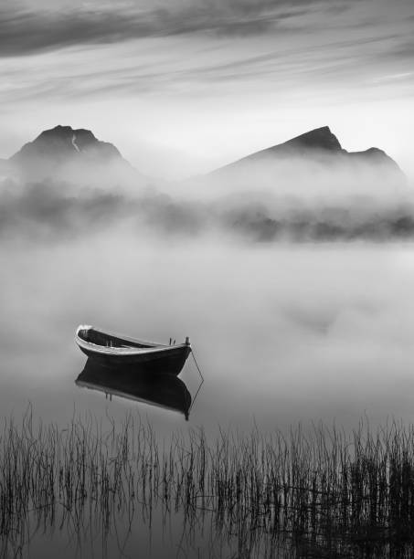 Very peaceful summer night with wooden boat and fog in Lofoten, Norway Very peaceful summer night with wooden boat and fog in Lofoten, Norway calm before the storm photos stock pictures, royalty-free photos & images