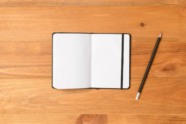 istock Open notebook and pencil on wooden floor 846874636