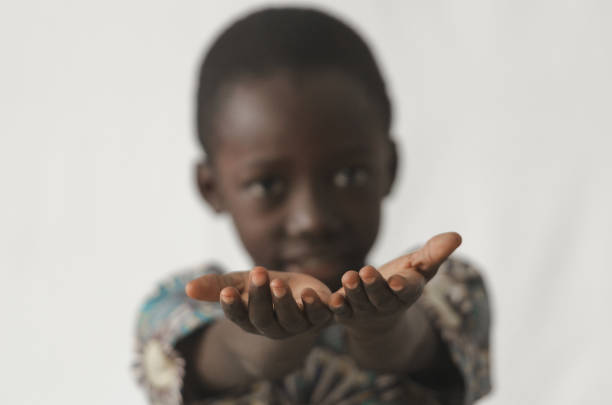 muchacho africano con sus manos abiertas como un concepto aislado sobre fondo blanco y borroso - malnourished fotografías e imágenes de stock