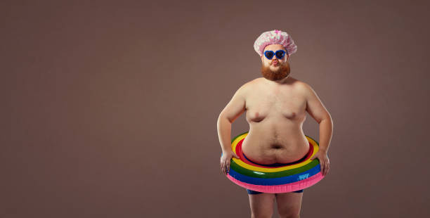 Funny fat bearded man in a swimsuit in for swimming inflatable ring.