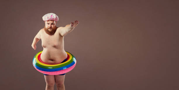 Funny fat bearded man in a swimsuit in for swimming inflatable ring.