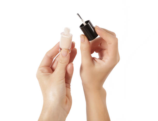 istock Hand with nude nail polish bottle isolated on white 846907778