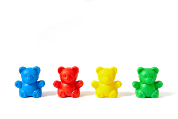 Small blue, red, yellow and green plastic toy bears isolated on white background stock photo