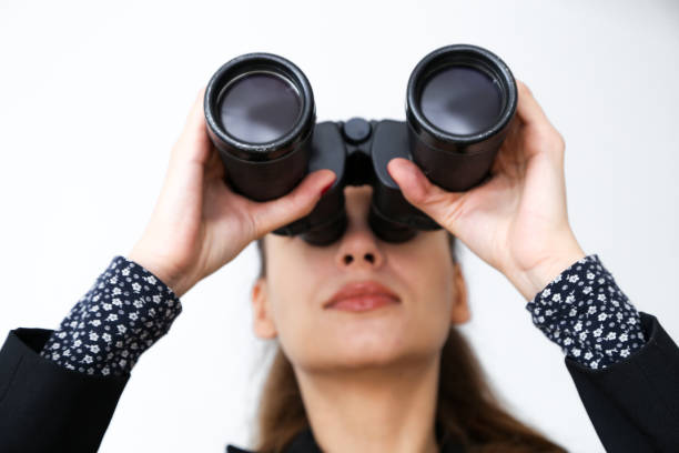 istock Girl on a white background looks through binoculars 846960312