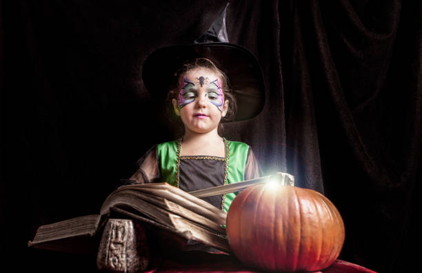 istock Little witch reads the Book of Spells 846972376