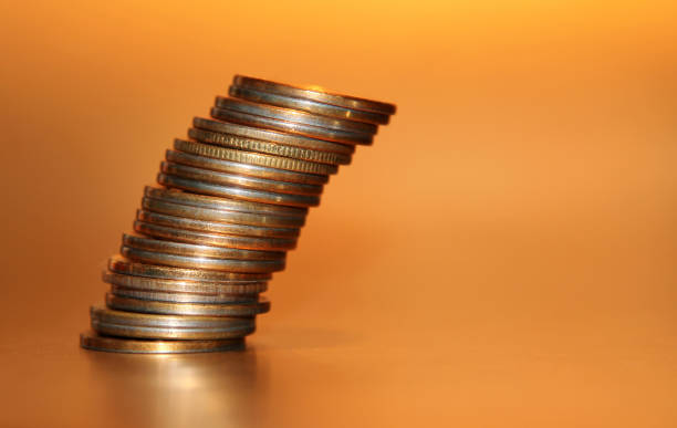 Falling stack of coins on a golden background Falling stack of coins on a golden background a penny saved stock pictures, royalty-free photos & images