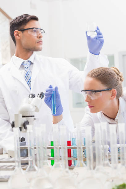 istock Focused scientists examining test tube and beaker 846990292