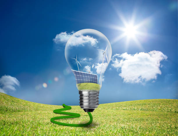 istock Light bulb showing solar panels and turbines in a field 846996668