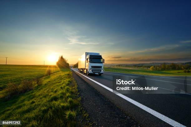 White Truck Driving On The Road In Landscape At Sunset Stock Photo - Download Image Now