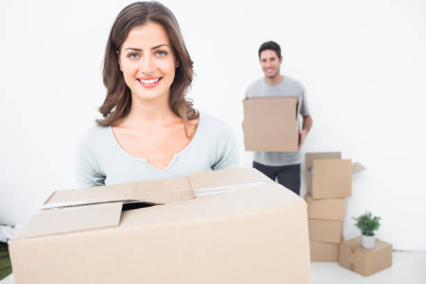 istock Pretty woman holding boxes in her new house 847002314