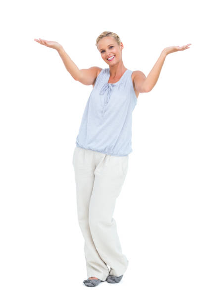 Blonde woman with arms raised smiling at camera on white background