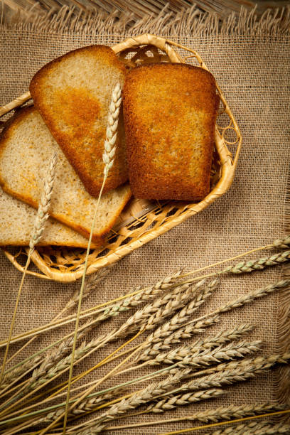 Toast bread in a wicker plate on wooden background. Top view