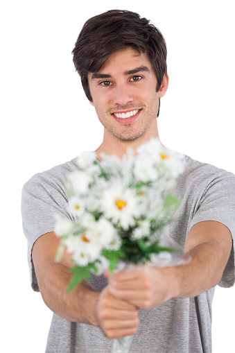 Young man offering a flower bouquet on a white background