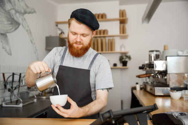 istock Coffee Business Concept - handsome bearded man in apron making coffee while standing at cafe 847025892