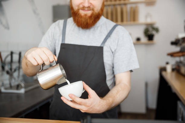 istock Coffee Business Concept - handsome bearded man in apron making coffee while standing at cafe 847025902