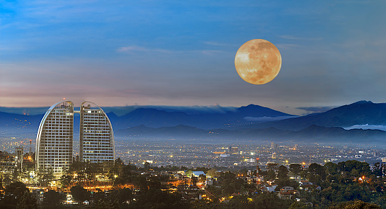 View of Bandung cityscape with a full moon in the sky