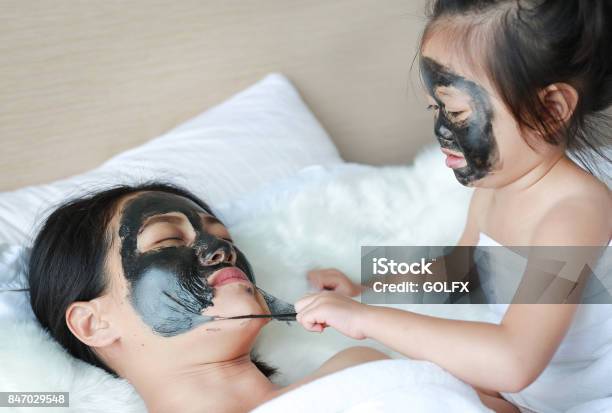 Child Girl Removed Black Mask From Her Mother Clean Face Stock Photo - Download Image Now