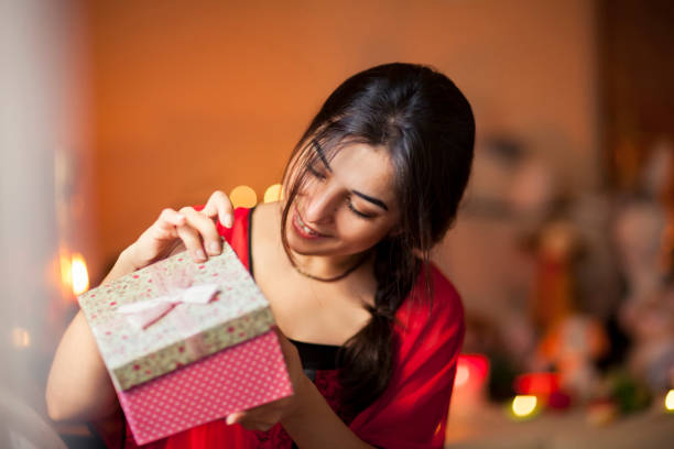 istock The woman opens the gift she received with great happiness. 847039802