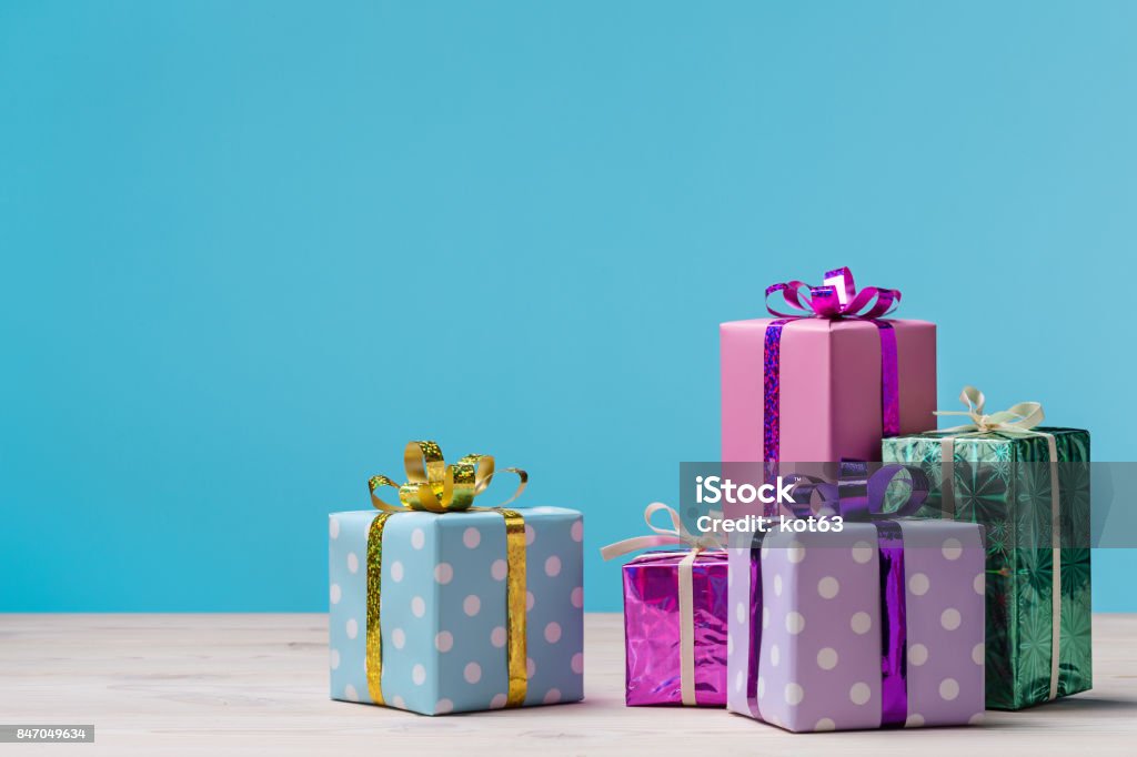 Many gift boxes on blue background. Gift boxes on wooden table, with space for text. Birthday Present Stock Photo