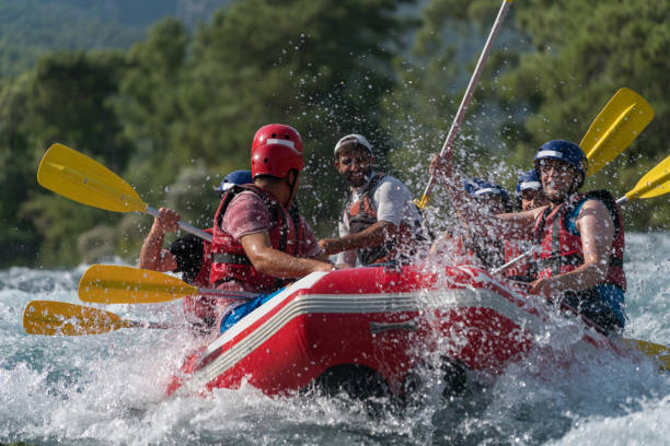 gruppe von menschen wildwasser rafting - white water rafting outdoor pursuit rafting rapid stock-fotos und bilder