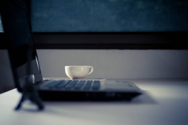istock Laptop and coffee cup on white table surface near window , selective focus. 847055026