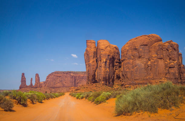 未舗装の道路と岩のモニュメント。モニュメント バレー、ユタ州の未舗装の道路 - usa dirt road rock sandstone ストックフォトと画像