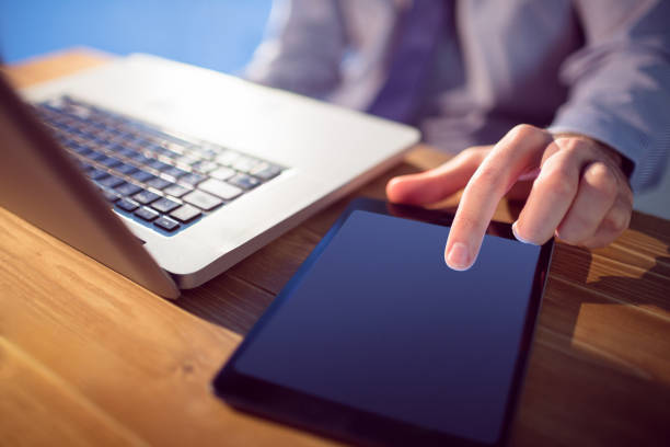 istock Businessman using laptop and tablet at desk 847076736