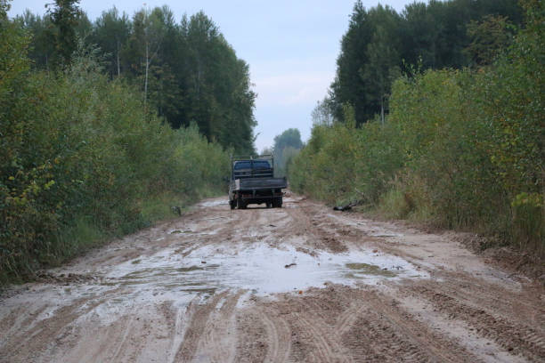 istock car rides on a rural forest road after a rain with mud and deep puddles 847084242
