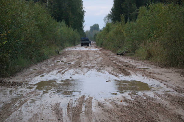 istock car rides on a rural forest road after a rain with mud and deep puddles 847084252