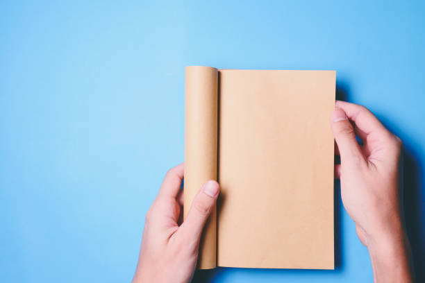 istock Top view of hands holding a blank book ready with copy space ready for text on blue background. 847088116