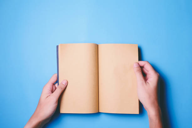 istock Top view of hands holding a blank book ready with copy space ready for text on blue background. 847088122