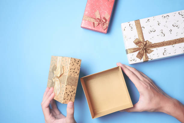 istock Top view of male hands opening a gift box, presents on blue background. 847088134