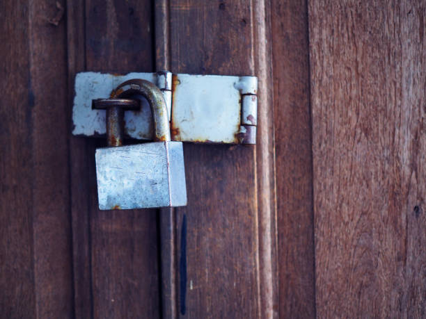 istock Old rusty grey iron lock, hinge, on Thai old local wooden door, close up 847089374