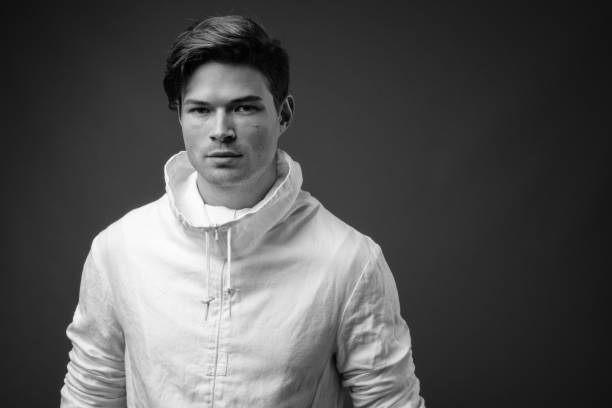 istock Studio shot of young handsome man wearing high collar white jacket against colored background 847093428