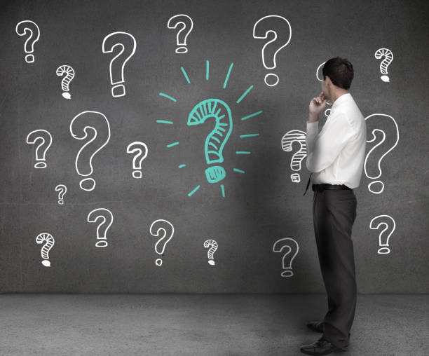 istock Businessman looking at drawings of question marks 847093566
