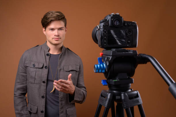 istock Studio shot of young handsome man vlogging while wearing denim jacket against colored background 847093700