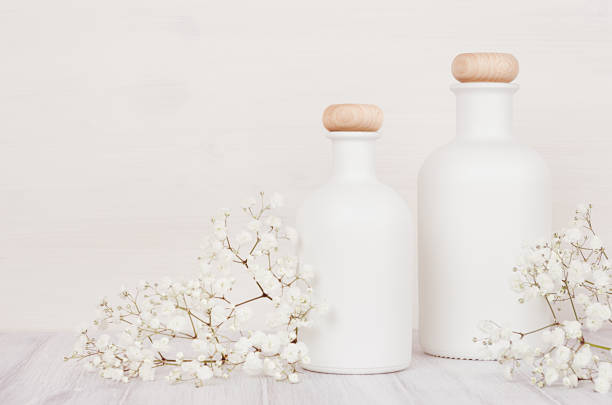 istock Blank white cosmetics bottles with small flowers on white wood board, mock up. 847096662