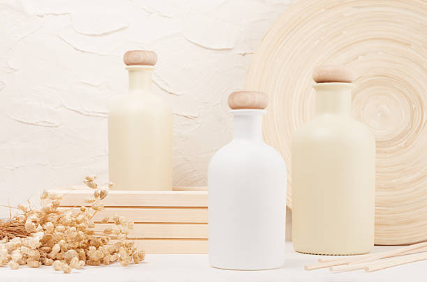 istock Blank beige cosmetics bottles with spikelets on white wood board, mock up. Soft elegant home decor for advertising, designers, branding identity, cover. 847097092