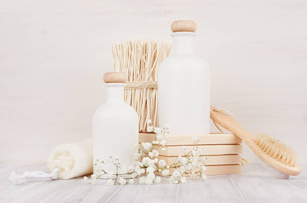 istock Blank white cosmetics bottles with comb, flowers on white wood board, mock up. Soft elegant bathroom decor for advertising, designers, branding identity, cover.