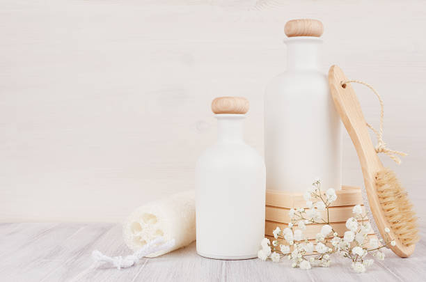 istock Blank white cosmetics bottles with comb, flowers on white wood board, mock up, copy space. 847099976