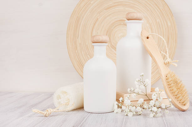 istock Soft elegant bathroom decor, template of white cosmetics bottles with comb, flowers on white wood board,copy space. 847100182